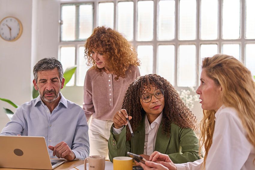 Integrantes de un equipo directivo trabajan juntos alrededor de una mesa