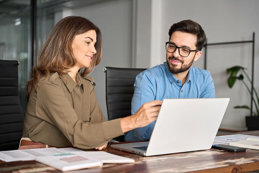 Dos docentes revisan juntos un plan de trabajo en una laptop