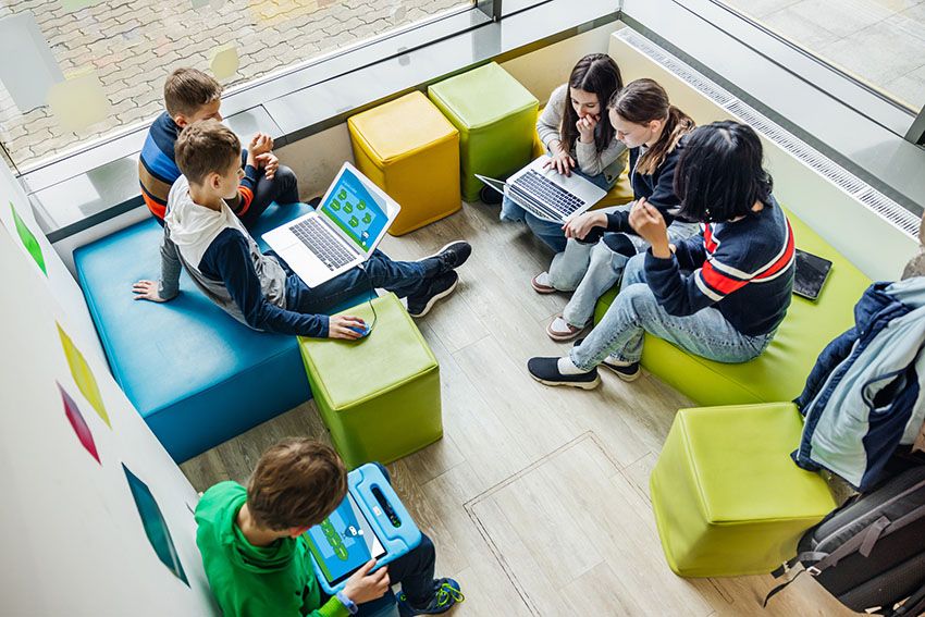 Estudiantes trabajan con laptops y tablets en un espacio de aprendizaje